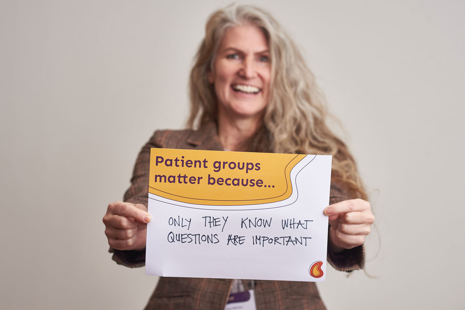 Woman holding a sign which reads patient groups matter because only they know what questions are important
