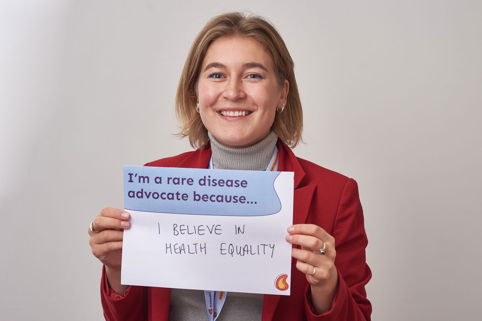 Photo of Phillipa Norman, holding a sign that reads 'I'm a rare disease advocate because I believe in health equity'