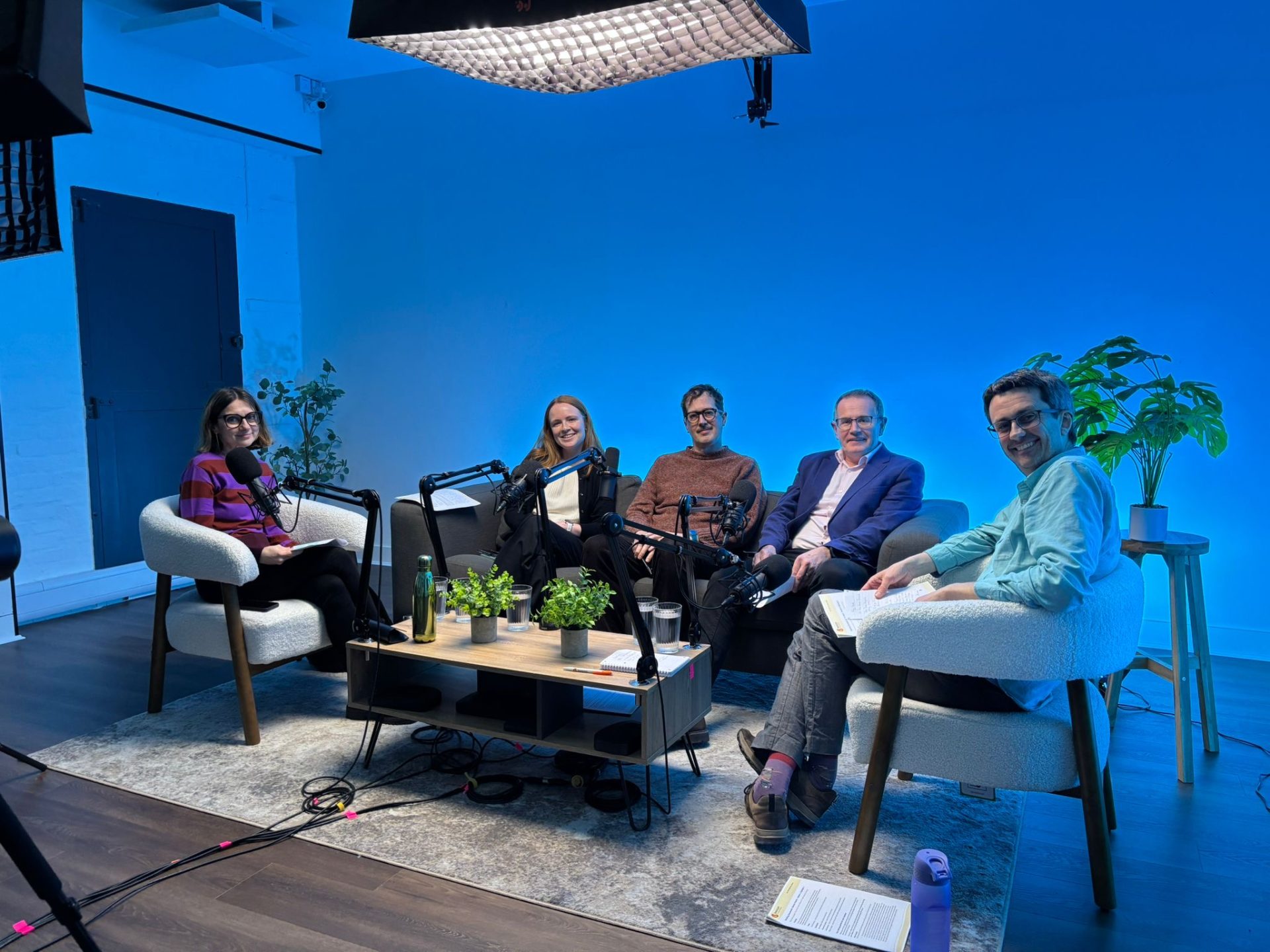 Rick Thompson, Nick Meade, Rosie Lindup, Julian Beach, and Alessandra Gaeta smiling at the camera in a podcast studio.