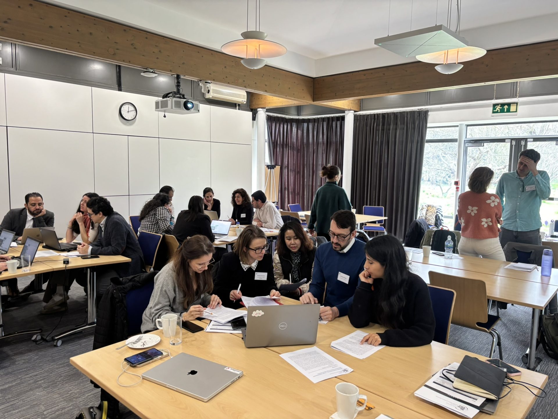 Bootcamp attendees working together at tables in groups of around 5. 