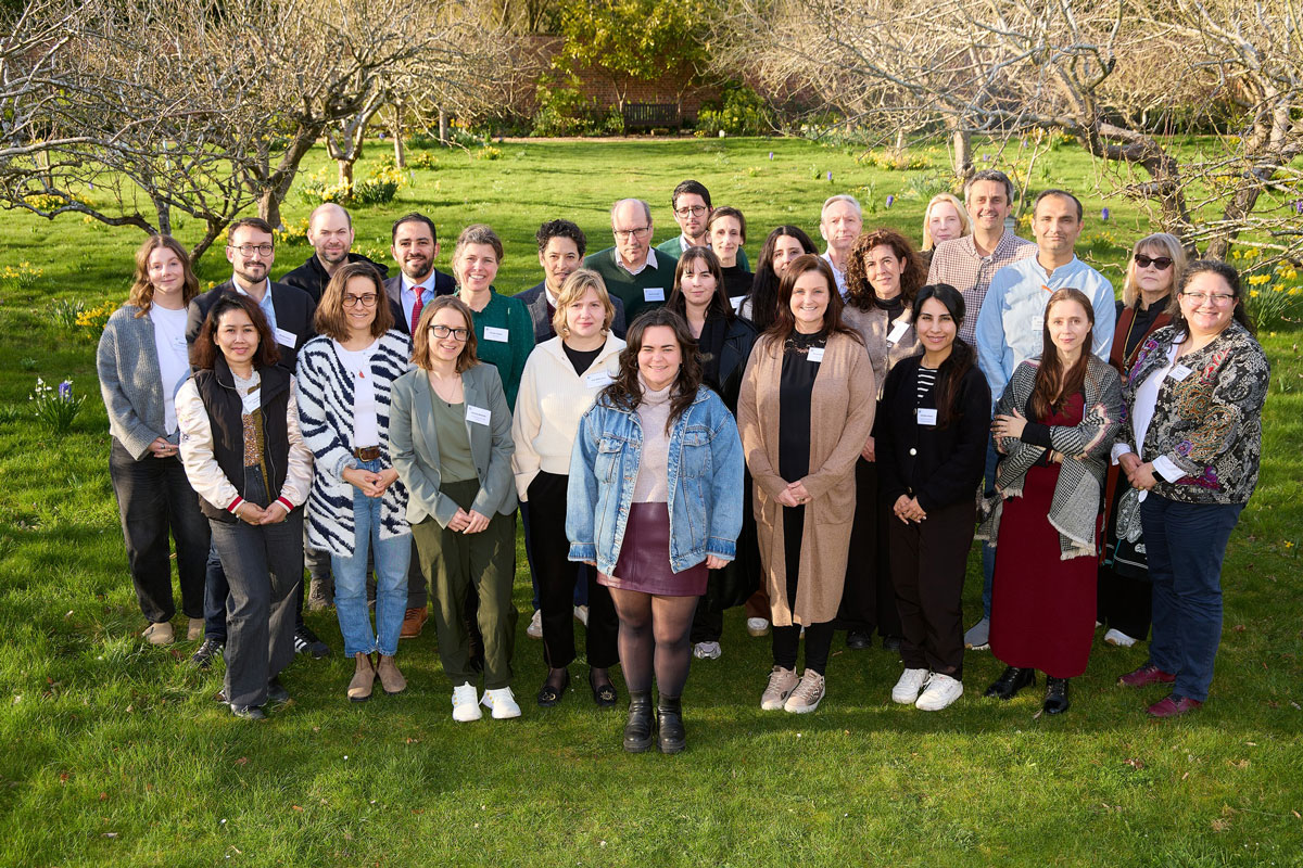 Group photo of Drug Repurposing Bootcamp attendees. They are stood outside on a sunny day, with trees in the background, and are smiling at the camera.