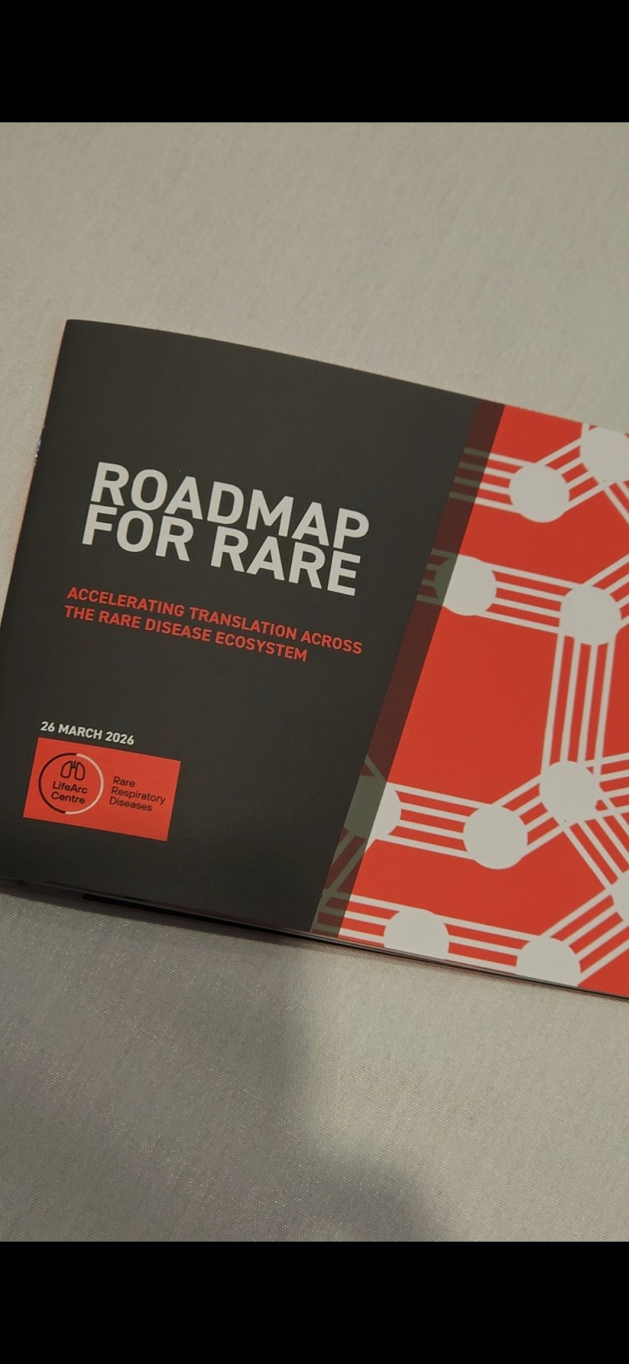 Event welcome pack. Red and grey background with white text that reads 'Roadmap for rare: Accelerating translation across the rare disease ecosystem'.