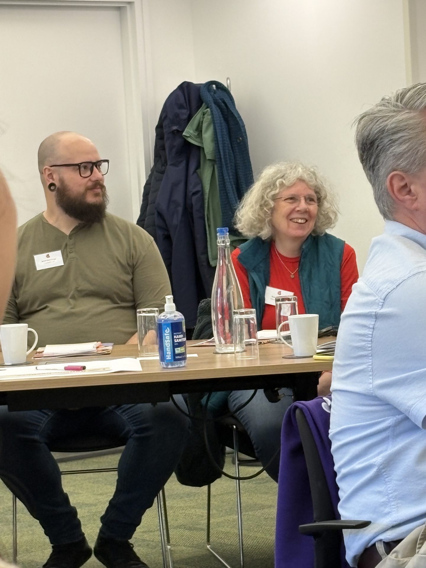 Close up photo of two masterclass attendees at a table, smiling.