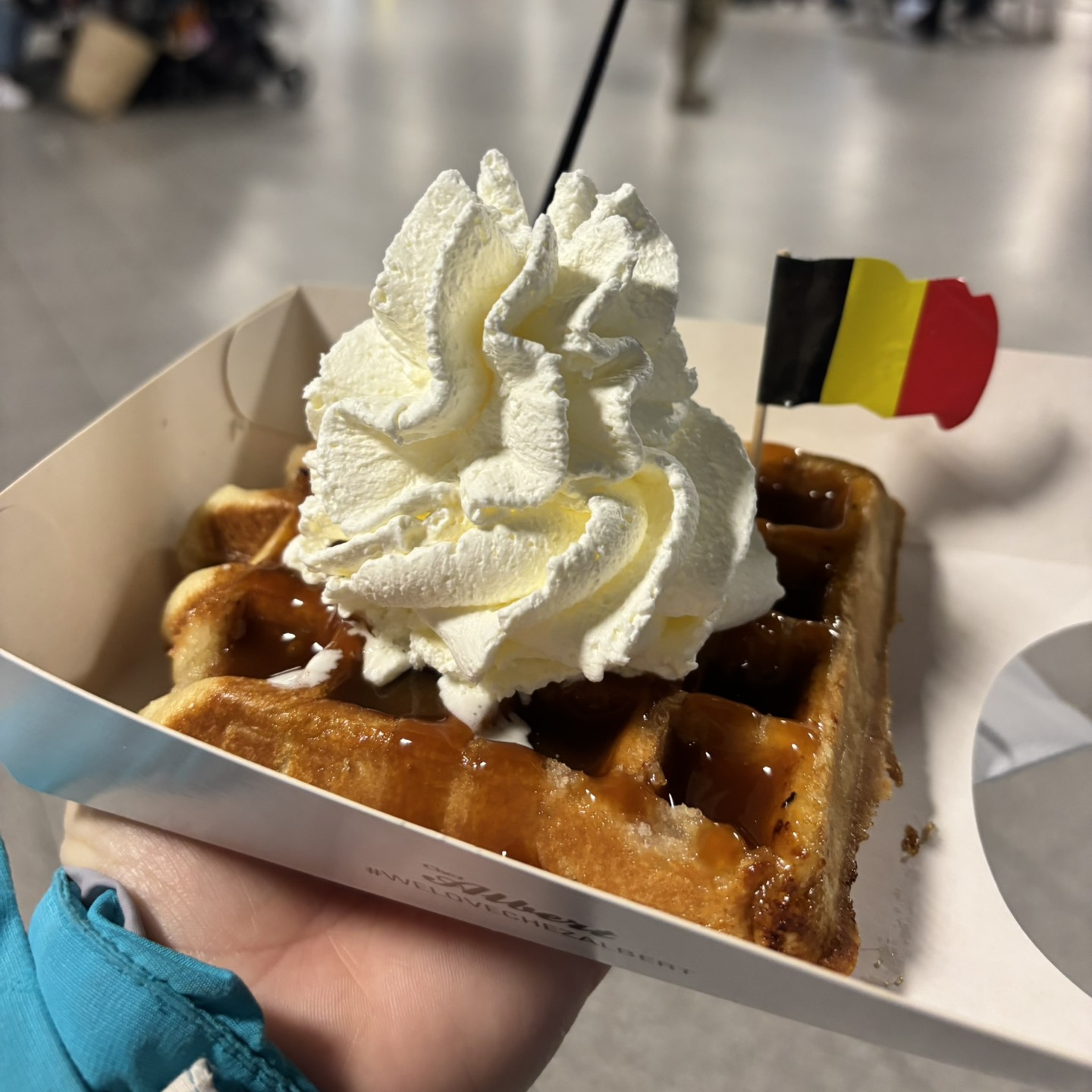 Belgian waffle with whipped cream with a small Belgian flag on a cocktail stick