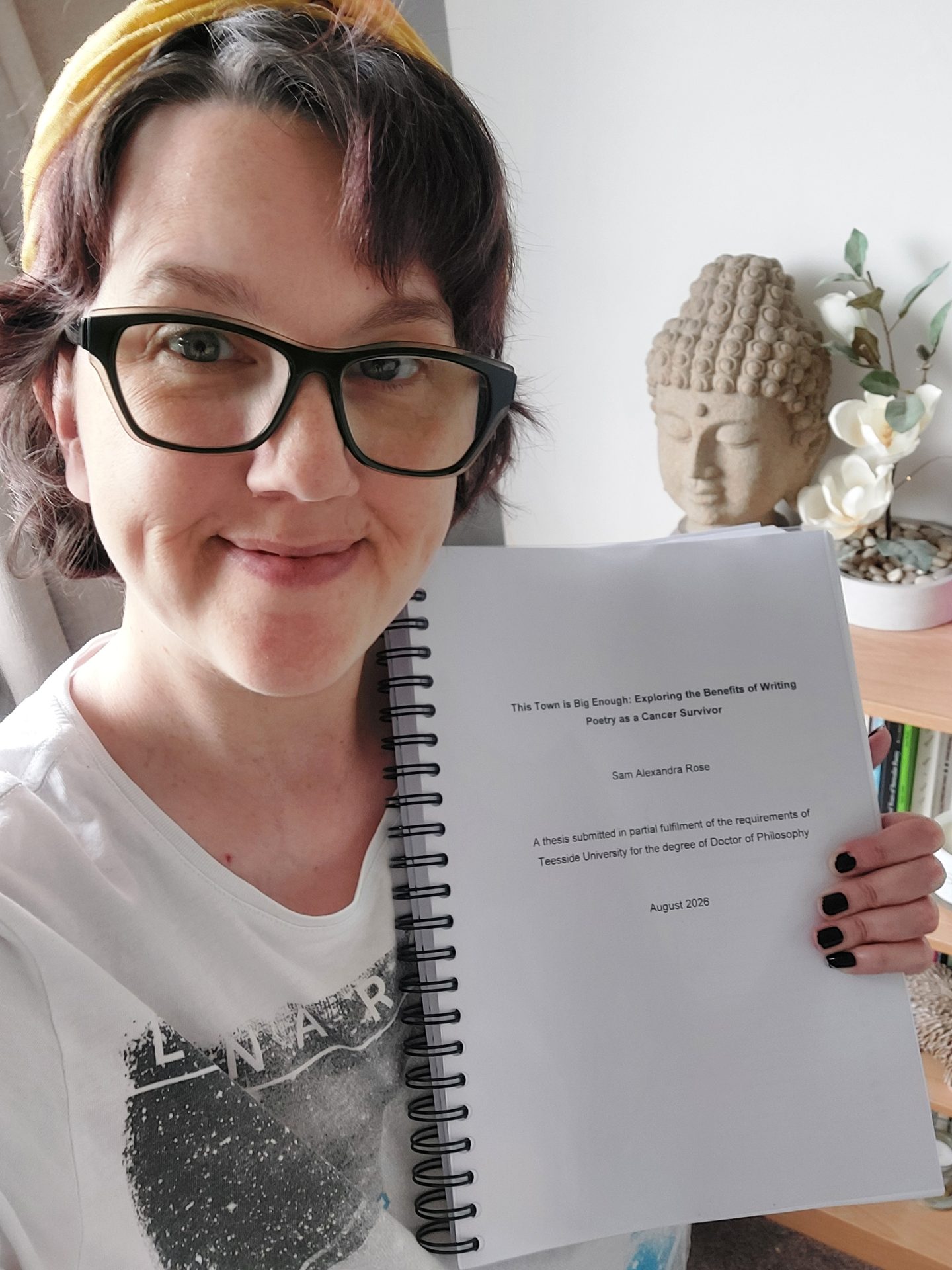 Sam holding their PhD thesis